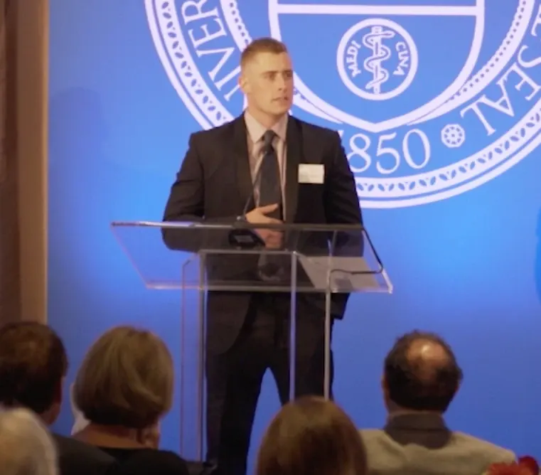 Joseph VanderStel speaking at a lectern in 2018